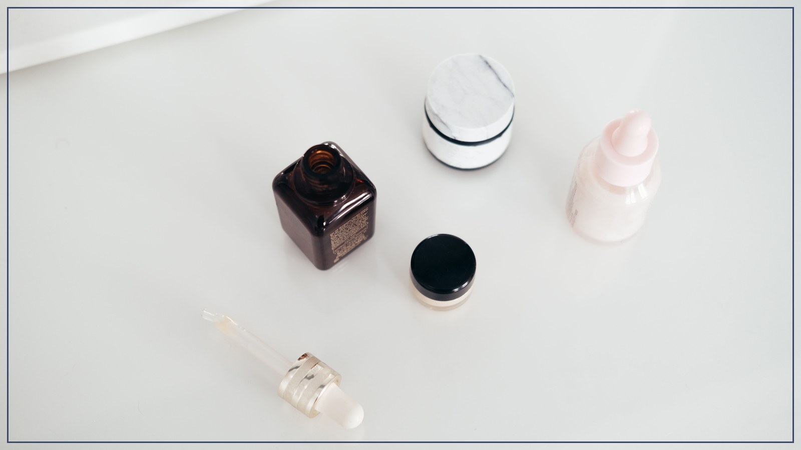 Minimalist skincare bottles and jars on a white surface, representing Japanese quasi-drug and cosmetic product categories